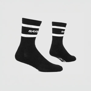Black socks with white stripes and visible branding on a light gray background